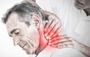 A person receives gentle back massage while another practitioner reviews a spine movement assessment nearby.