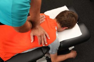 Person carefully rolling to the side and pushing up from bed while managing lower back pain.