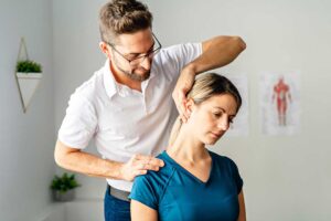Person drinking water after a walk while stretching the lower back in a bright home setting.