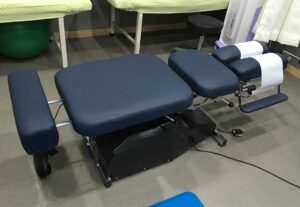 Older adult practicing supported balance exercises beside a chair in a bright home.