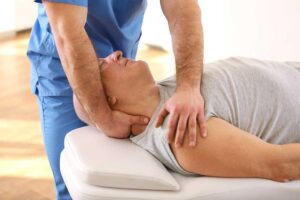 Person performing gentle balance exercises beside a sturdy chair in a bright home living room.